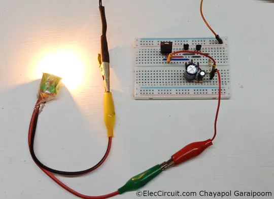 12V three transistor relaxation oscillator flasher blinker circuit tested on breadboard with 12V 8W incandescent bulb load